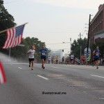 Early runners approach American Flags at the Peachtree Road Race in Atlanta
