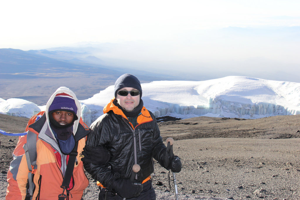 Trekker and guide walking up to Uhuru Peak in Kilimanjaro